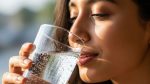 Woman drinking a glass of chilled sparkling water from the DNA Water Bar