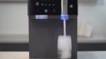 Close-up of the DNA Water Bar dispensing chilled water into a glass