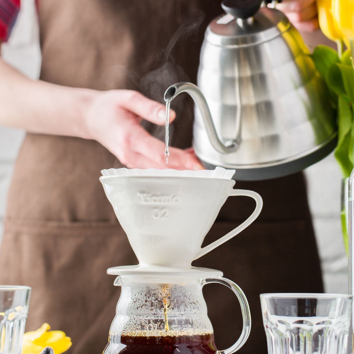Pour-over coffee being brewed in a bright kitchen