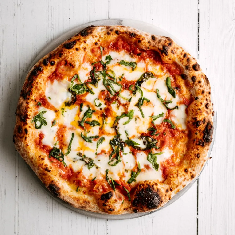 A margherita pizza with fresh basil
