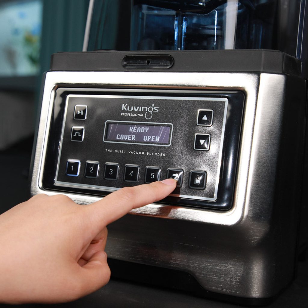 Hand pressing a preset button on the Kuvings CB1000 control panel