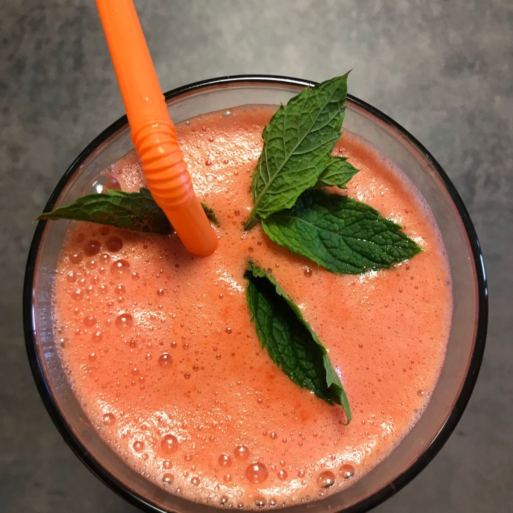 Orange fruit smoothie with mint seen from above, blended in a Kuvings CB1000