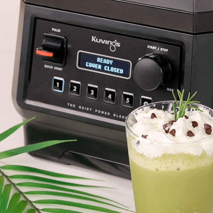 Green smoothie poured beside the Kuvings CB850 control panel