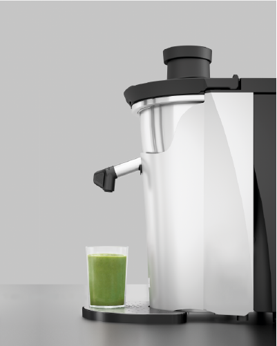 The Zumex Multifruit on a service counter beside a glass of fresh green juice
