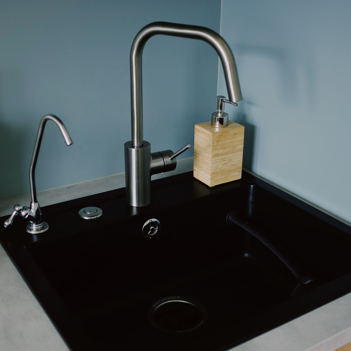 Black kitchen sink with a small dedicated drinking-water faucet beside the main mixer