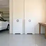 Huawei Power-M 10kW 20kWh system installed on a garage wall beside a parked car