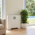 Huawei Power-M 5kWh backup power system against a living room wall beside an armchair and a potted plant