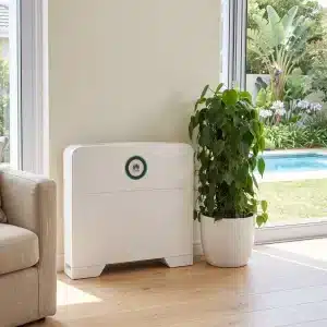 Huawei Power-M 5kWh backup power system against a living room wall beside an armchair and a potted plant