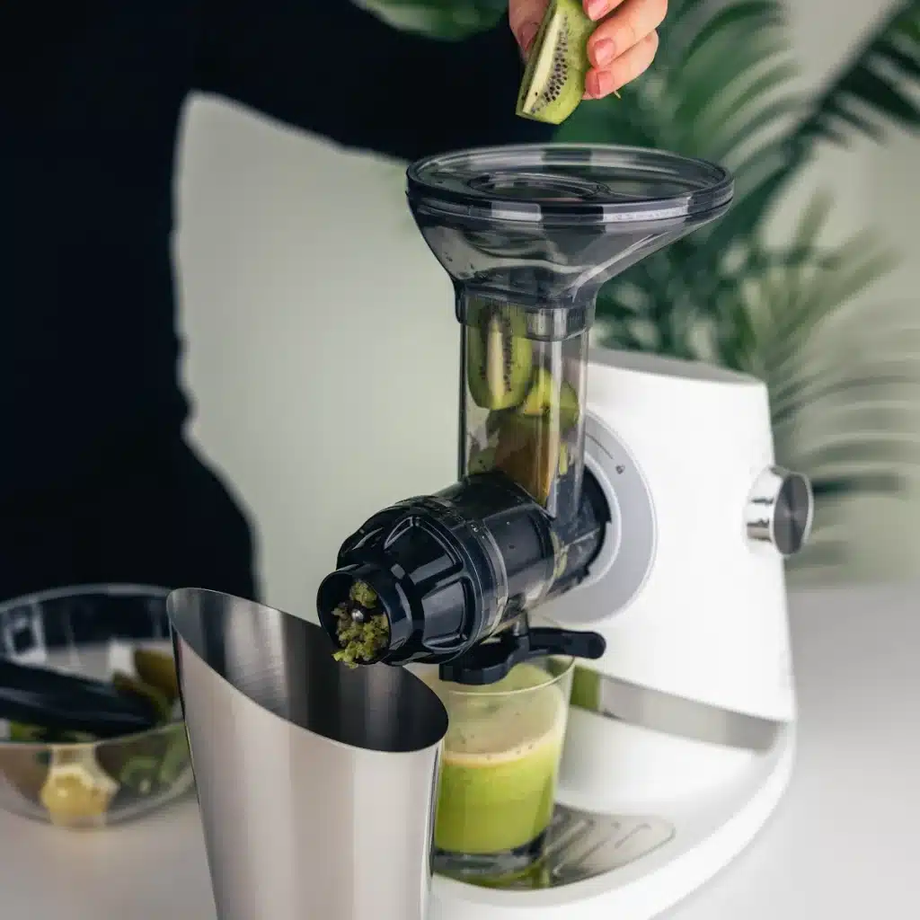 Feeding kiwi into the Sana 727 Supreme in Soft White for fresh green juice